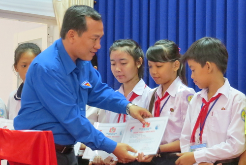 Anh Nguyễn Chí Công – Phó Bí thư Thường trực Tỉnh đoàn, Chủ tịch Hội LHTN Việt Nam tỉnh Cà Mau trao học bỗng cho các em
